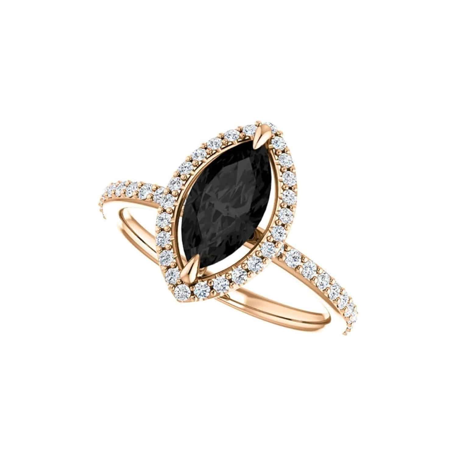 A close-up view of a marquise cut diamond ring, highlighting the 10x5 MM black onyx center stone and prong setting.