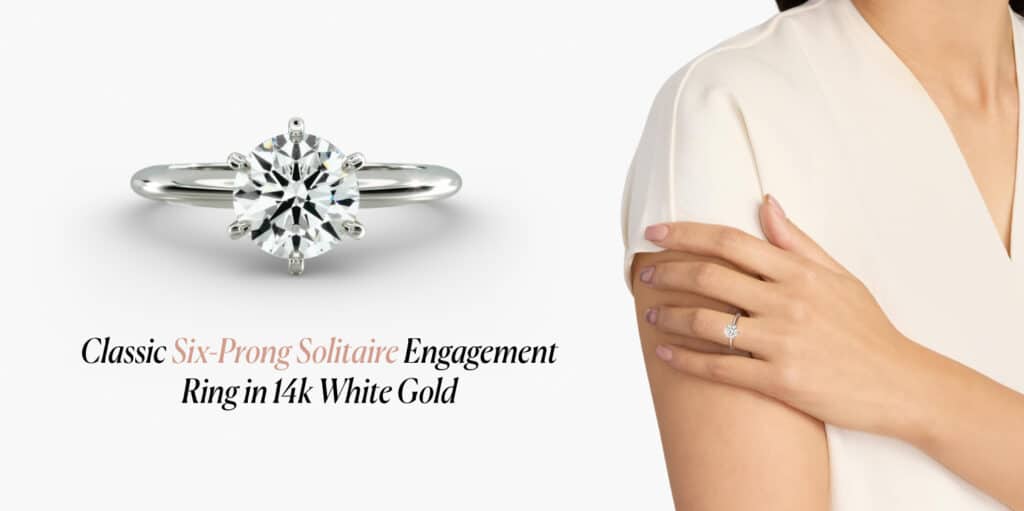 Close-up of a classic six-prong solitaire engagement ring in 14k white gold, featuring a round brilliant diamond worn on a woman's finger.