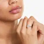 A woman's hand wearing a magnificent James Allen 4 carat diamond ring, showcasing the D-VVS1 round brilliant center stone and pavé band.