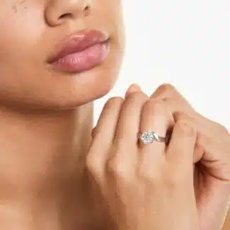 A woman's hand wearing a magnificent James Allen 4 carat diamond ring, showcasing the D-VVS1 round brilliant center stone and pavé band.