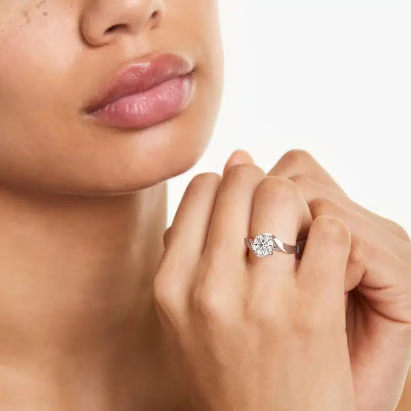 A woman's hand wearing a magnificent James Allen 4 carat diamond ring, showcasing the D-VVS1 round brilliant center stone and pavé band.
