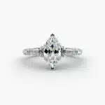 A close-up studio shot of a marquise cut diamond ring, highlighting the straight lines of the tapered baguette side stones against the center diamond.