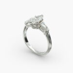 A close-up studio shot of a marquise cut diamond ring, highlighting the straight lines of the tapered baguette side stones against the center diamond.