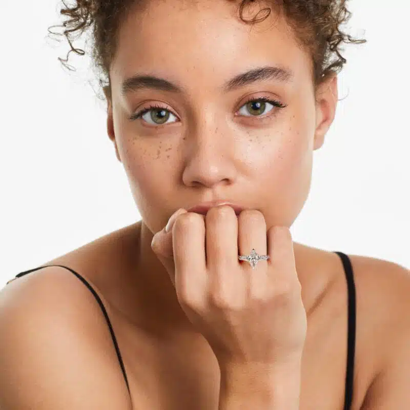 A woman's hand wearing a large marquise diamond ring with baguettes, showcasing the 5.00 ct. lab-grown center stone and platinum band.