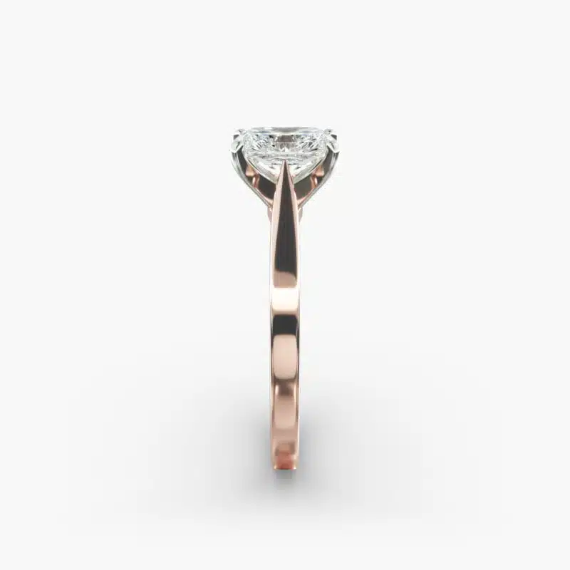 A close-up view of a rectangular radiant cut diamond solitaire, highlighting the warm rose gold band and large 7.00 ct. stone.