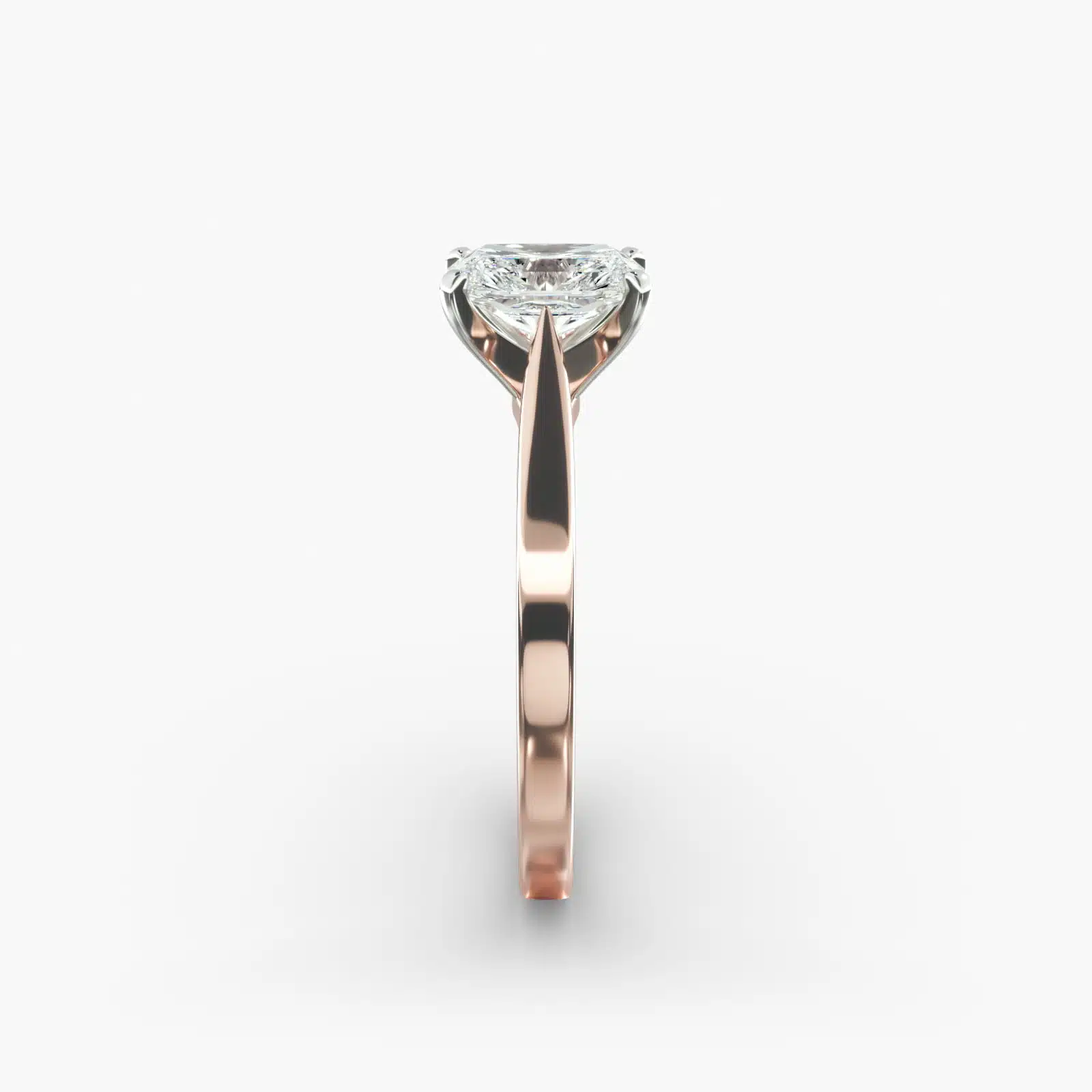 A close-up view of a rectangular radiant cut diamond solitaire, highlighting the warm rose gold band and large 7.00 ct. stone.