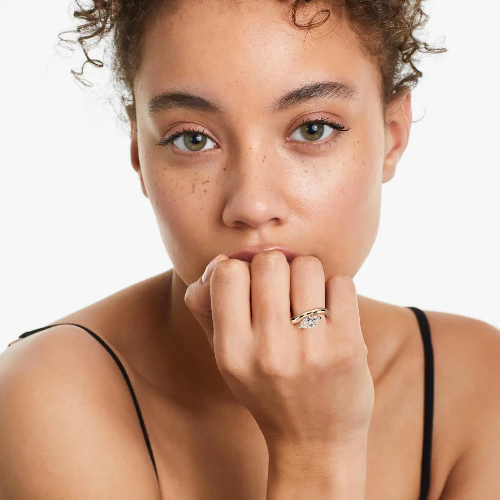 A woman's hand wearing a massive marquise solitaire diamond engagement ring with a 7.00 ct. lab-grown center stone in a 14K yellow gold setting.