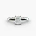 A close-up side view of a 6 ct radiant cut diamond ring, showcasing the delicate 1.60mm band and the hidden halo accent diamonds.
