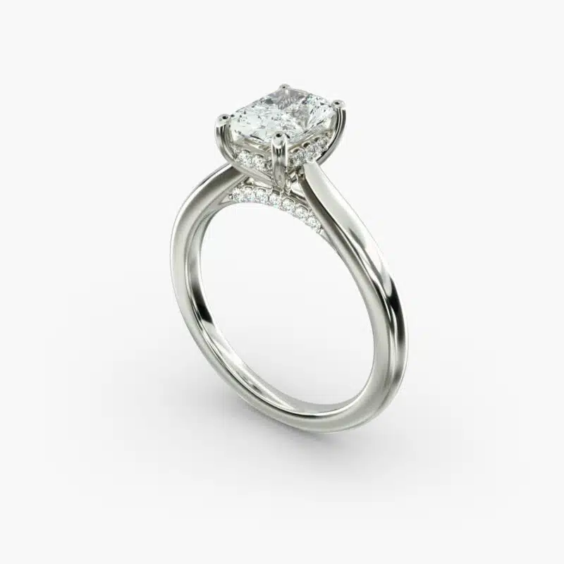 A close-up side view of a 6 ct radiant cut diamond ring, showcasing the delicate 1.60mm band and the hidden halo accent diamonds.