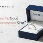 Featured image for blog post: A brilliant solitaire engagement ring rests in the open Blue Nile signature navy blue box, with the title 'Is Blue Nile Good for Engagement Rings?' overlaid.