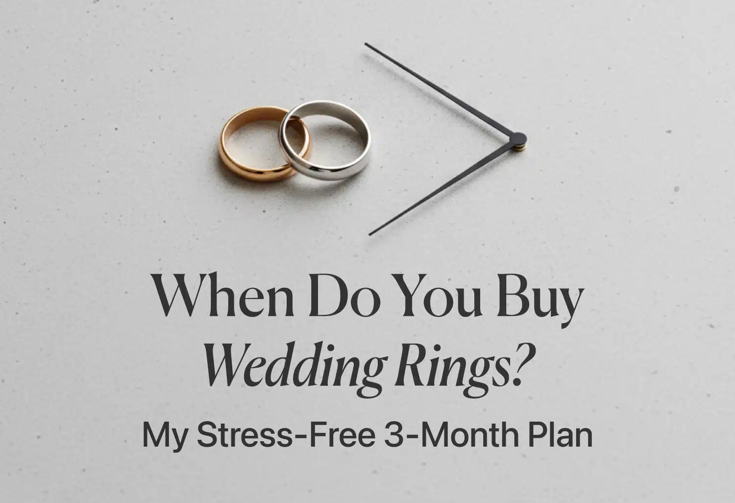 Minimalist image featuring two wedding rings (gold and silver) next to black clock hands set on a gray background, illustrating the headline "When Do You Buy Wedding Rings? My Stress-Free 3-Month Plan."