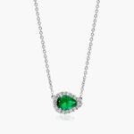 An East-West Pear Emerald (0.65 CT min) and Diamond Halo Necklace (0.14 CTW) in 18K White Gold, a modern and high-quality option among Luxury Push Present Ideas.