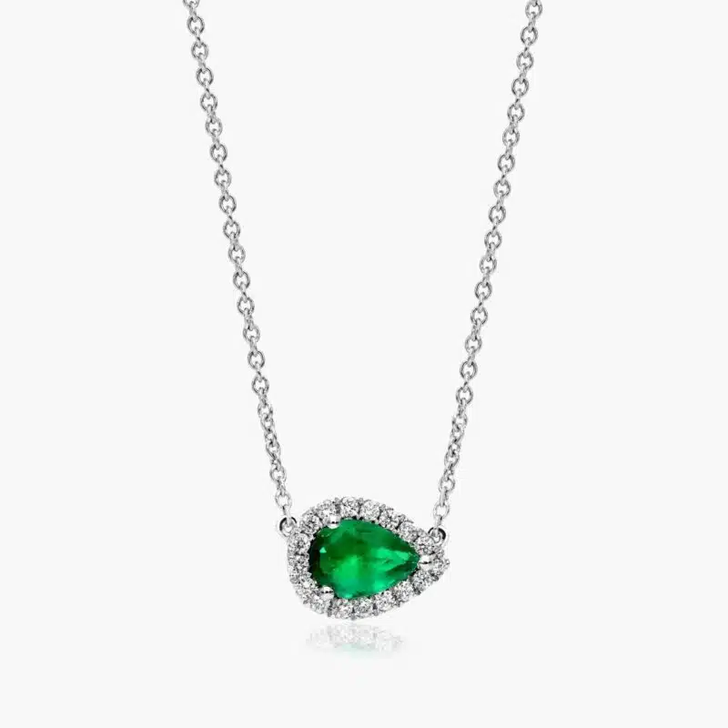 An East-West Pear Emerald (0.65 CT min) and Diamond Halo Necklace (0.14 CTW) in 18K White Gold, a modern and high-quality option among Luxury Push Present Ideas.