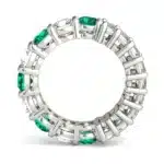 An Alternating Emerald Paradox Eternity Band from Charles & Colvard, featuring alternating lab-grown round and emerald-cut stones with emerald color accents, a unique option among Luxury Push Present Ideas.