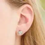 A pair of Heart Four-Prong Basket Stud Earrings featuring 2 CTW DEW Moissanite in 14K White Gold, a brilliant alternative for Luxury Push Present Ideas and a diamond earrings push present model view.