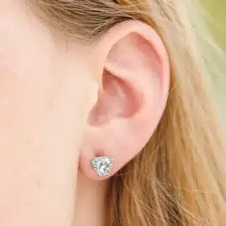 A pair of Heart Four-Prong Basket Stud Earrings featuring 2 CTW DEW Moissanite in 14K White Gold, a brilliant alternative for Luxury Push Present Ideas and a diamond earrings push present model view.