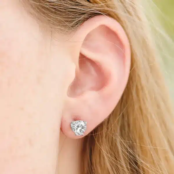 Moissanite Heart Four-Prong Basket Stud model view A pair of Heart Four-Prong Basket Stud Earrings featuring 2 CTW DEW Moissanite in 14K White Gold, a brilliant alternative for Luxury Push Present Ideas and a diamond earrings push present model view.