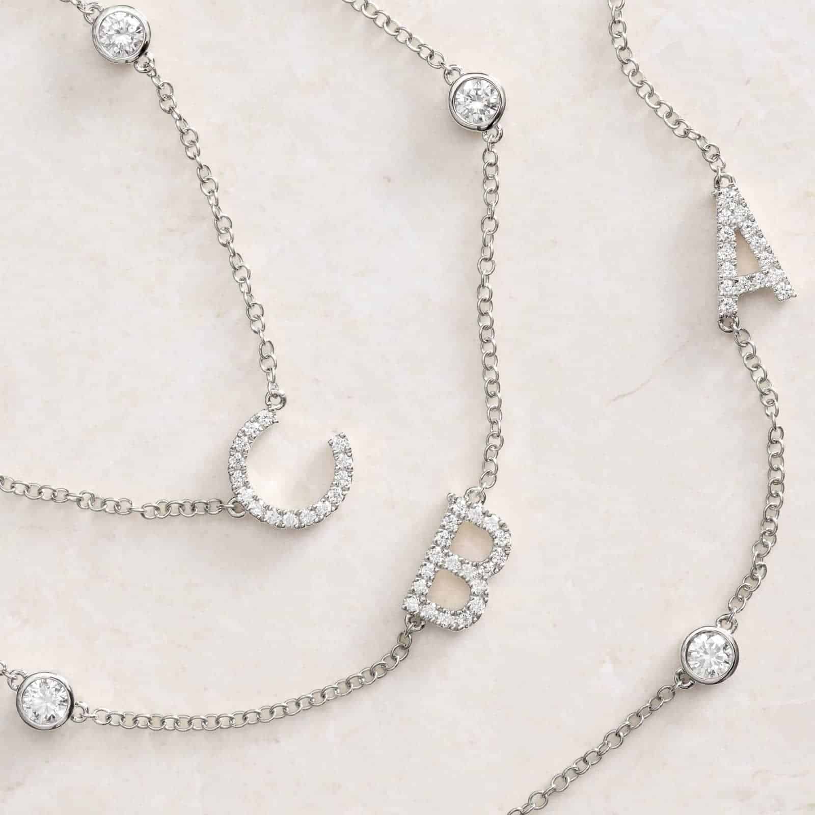 A personalized station initial necklace in 14K White Gold featuring 0.95 CTW lab-grown diamonds in a bezel setting, one of the best Luxury Push Present Ideas.