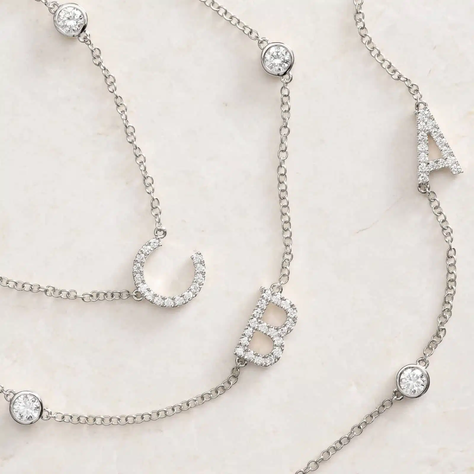 A personalized station initial necklace in 14K White Gold featuring 0.95 CTW lab-grown diamonds in a bezel setting, one of the best Luxury Push Present Ideas.