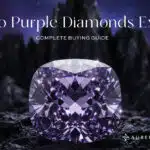 Feature image: A large, brilliant-cut purple diamond set on dark, craggy ground, with sharp black mountains and a dark purple sky in the background. The text reads "Do Purple Diamonds Exist? Complete Buying Guide."