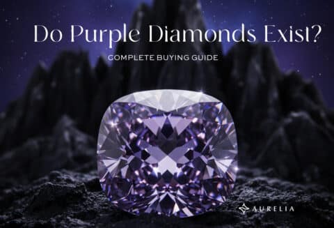 Feature image: A large, brilliant-cut purple diamond set on dark, craggy ground, with sharp black mountains and a dark purple sky in the background. The text reads "Do Purple Diamonds Exist? Complete Buying Guide."