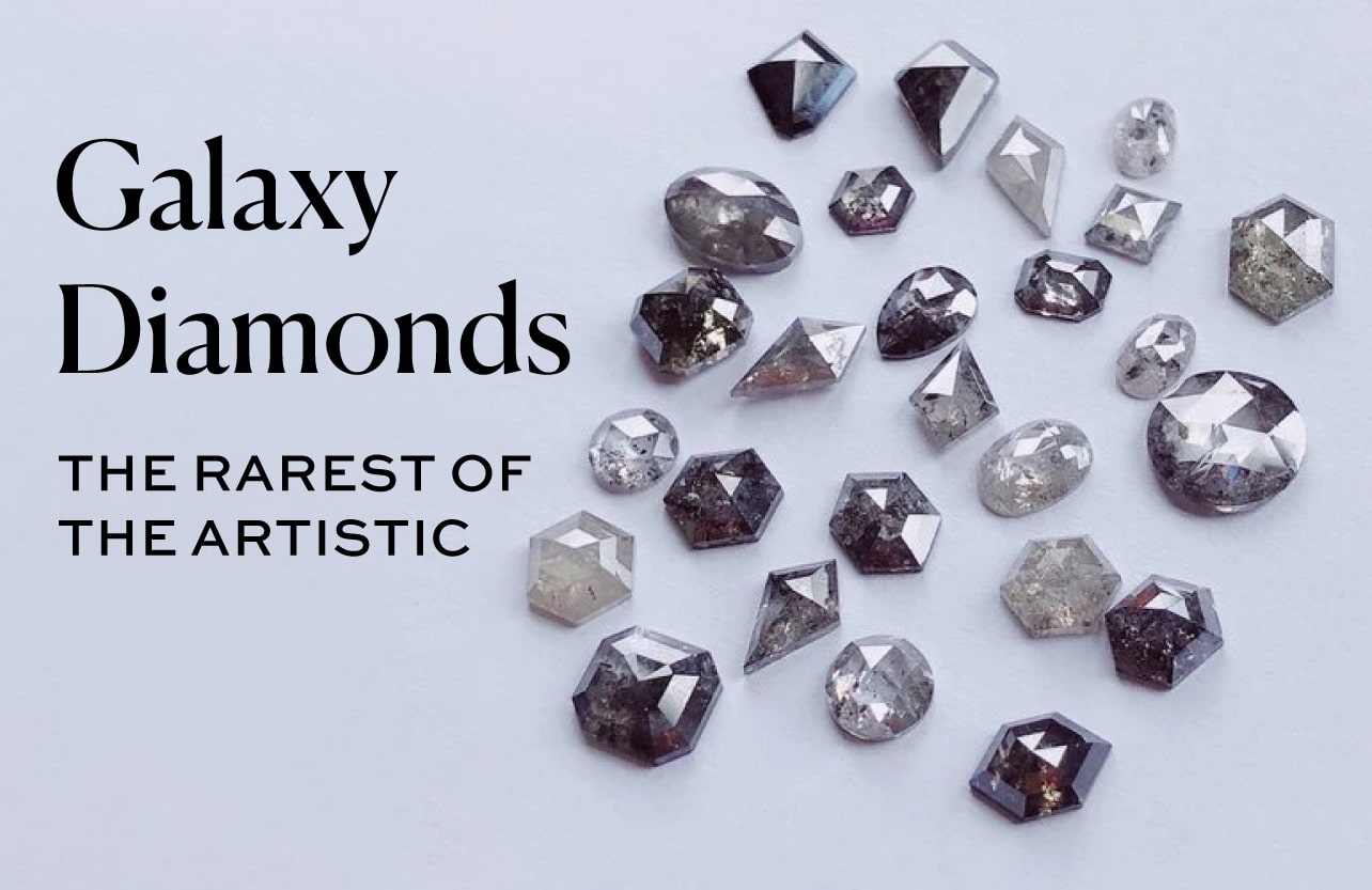 A collection of rough and geometric-cut Galaxy Diamonds, featuring very dark gray to black body color and a dense field of reflective inclusions that resemble a starry night sky. This illustrates the rarest and most dramatic type of artistic included gray diamond.