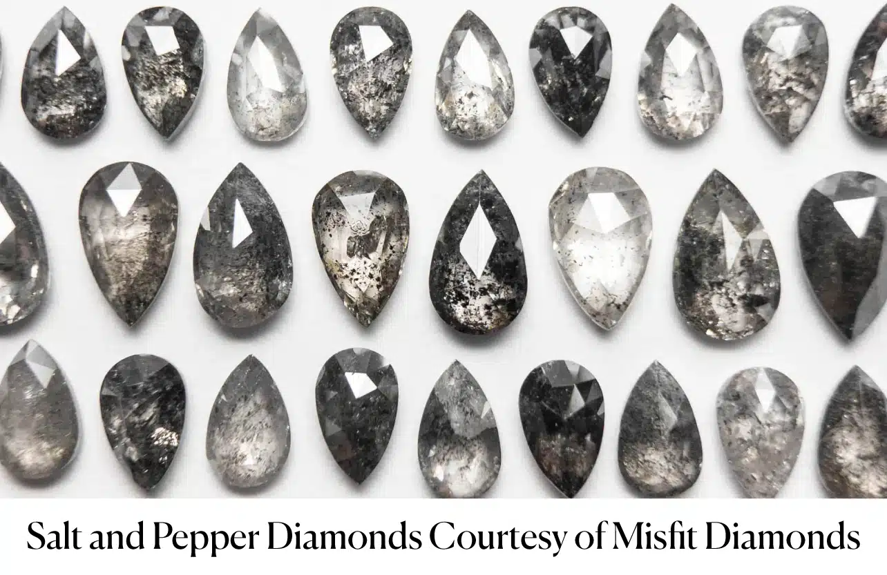 A grid of various pear-shaped salt and pepper diamonds, showcasing the visible black and white mineral inclusions that create their unique patterns. This image demonstrates the distinct artistic style of inclusion-based gray diamonds versus uniform Fancy Gray diamonds.