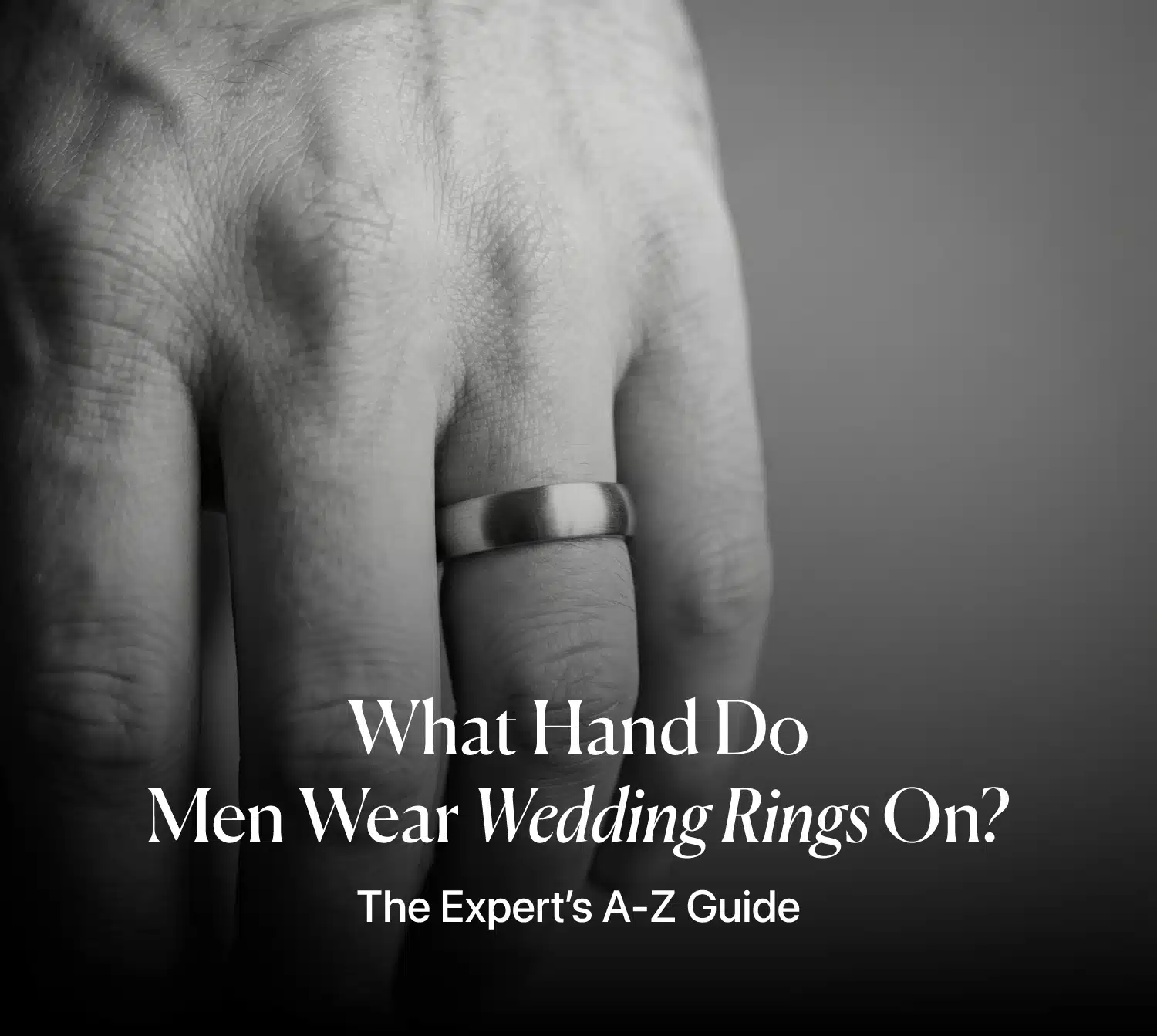 Close-up of a man's hand wearing a brushed metal wedding band on the left ring finger, with the article title overlay: "What Hand Do Men Wear Wedding Rings On? The Expert’s A-Z Guide."