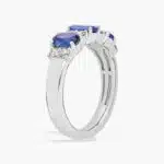A 14K White Gold 3 Stone Diamond Rings With Sapphires ring (3.60 mm wide) featuring three Oval Blue Sapphires set in prongs, accented by 0.31 CTW Round Diamonds on the shank.
