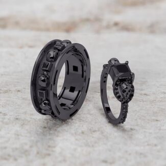 A set of Black Wedding Ring Sets His and Hers featuring a Princess Cut Black Moissanite Skull Engagement Ring and matching wedding band in 925 Sterling Silver with a Gun Metal finish.