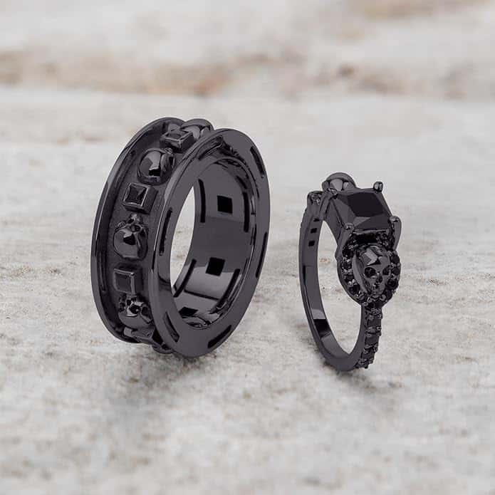 A set of Black Wedding Ring Sets His and Hers featuring a Princess Cut Black Moissanite Skull Engagement Ring and matching wedding band in 925 Sterling Silver with a Gun Metal finish.