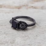 A set of Black Wedding Ring Sets His and Hers featuring a Princess Cut Black Moissanite Skull Engagement Ring and matching wedding band in 925 Sterling Silver with a Gun Metal finish.