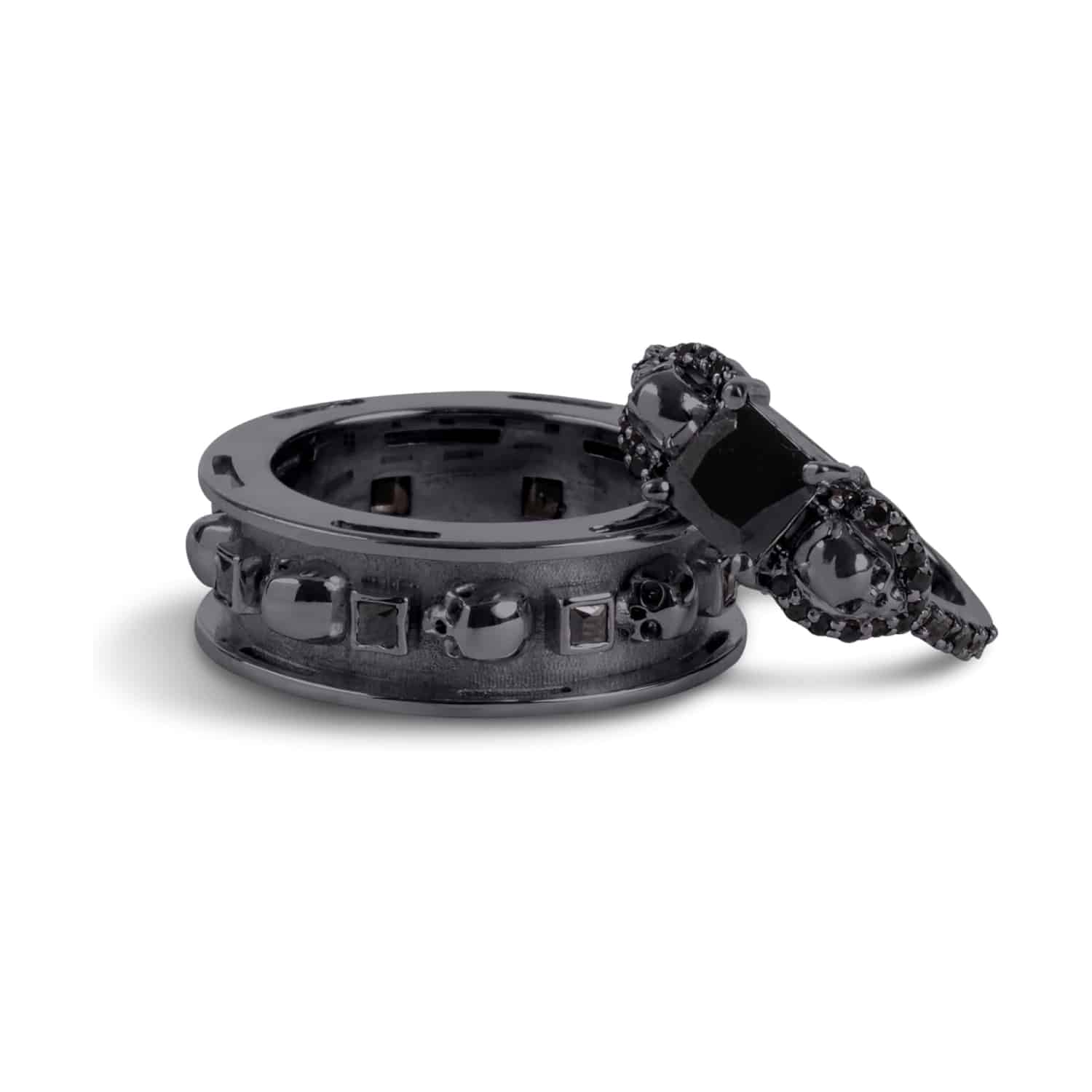 A set of Black Wedding Ring Sets His and Hers featuring a Princess Cut Black Moissanite Skull Engagement Ring and matching wedding band in 925 Sterling Silver with a Gun Metal finish.