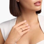 A Riviera Noir Pavé Black Diamond Black Wedding Rings For Women band (1.50mm) in 18K Yellow Gold with 0.50 CTW black diamonds in women hands view.