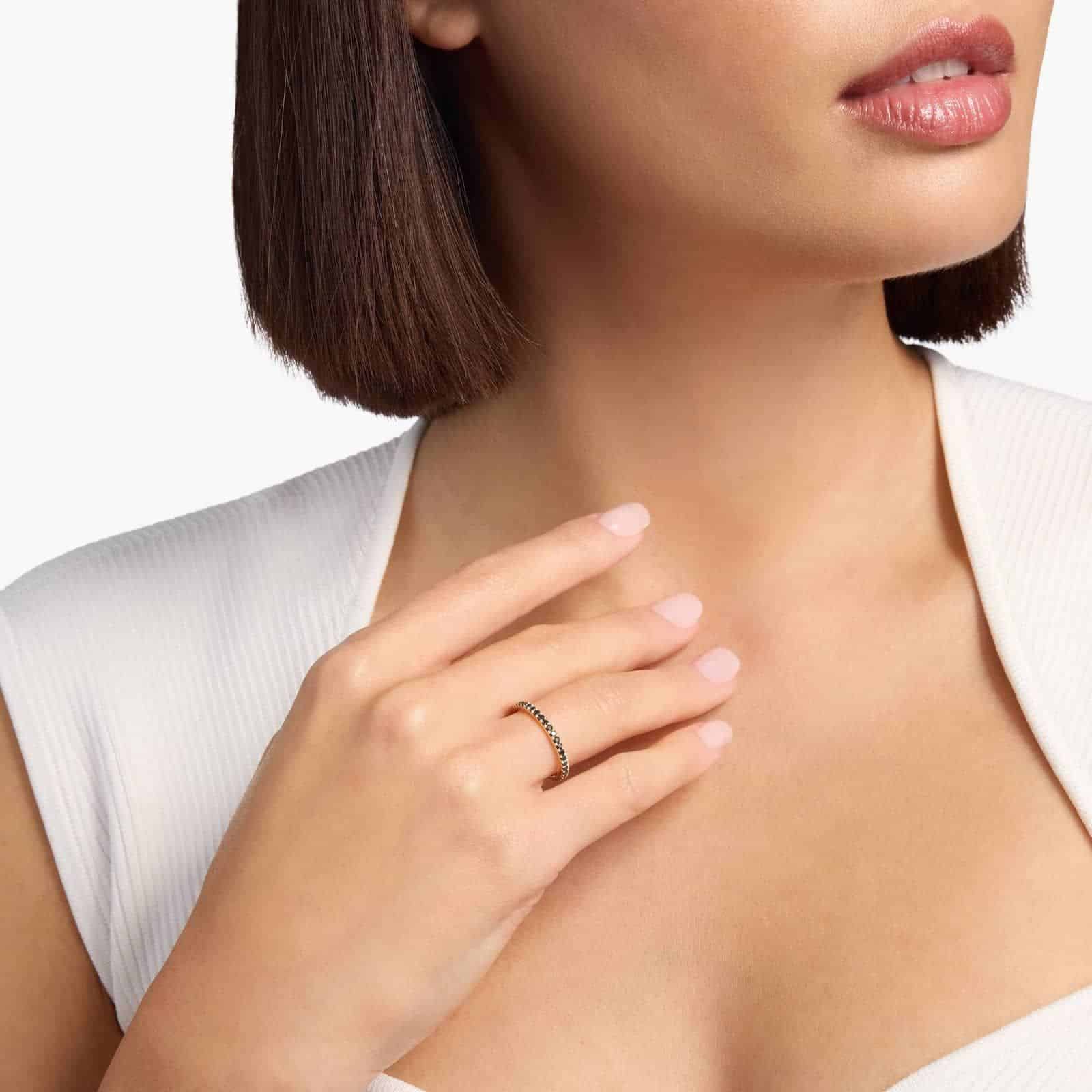 A Riviera Noir Pavé Black Diamond Black Wedding Rings For Women band (1.50mm) in 18K Yellow Gold with 0.50 CTW black diamonds in women hands view.