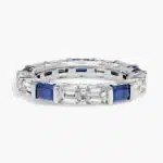 An Alternating East-West Emerald Cut Sapphire and Diamond Blue Wedding Rings For Women band (3.30mm) in 14K White Gold with over 2.5 CTW of stones.