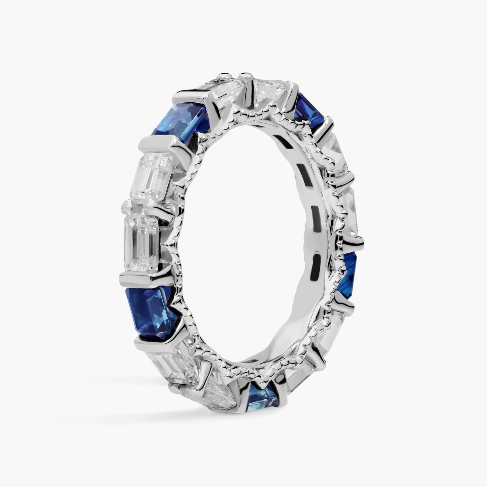 An Alternating East-West Emerald Cut Sapphire and Diamond Blue Wedding Rings For Women band (3.30mm) in 14K White Gold with over 2.5 CTW of stones.