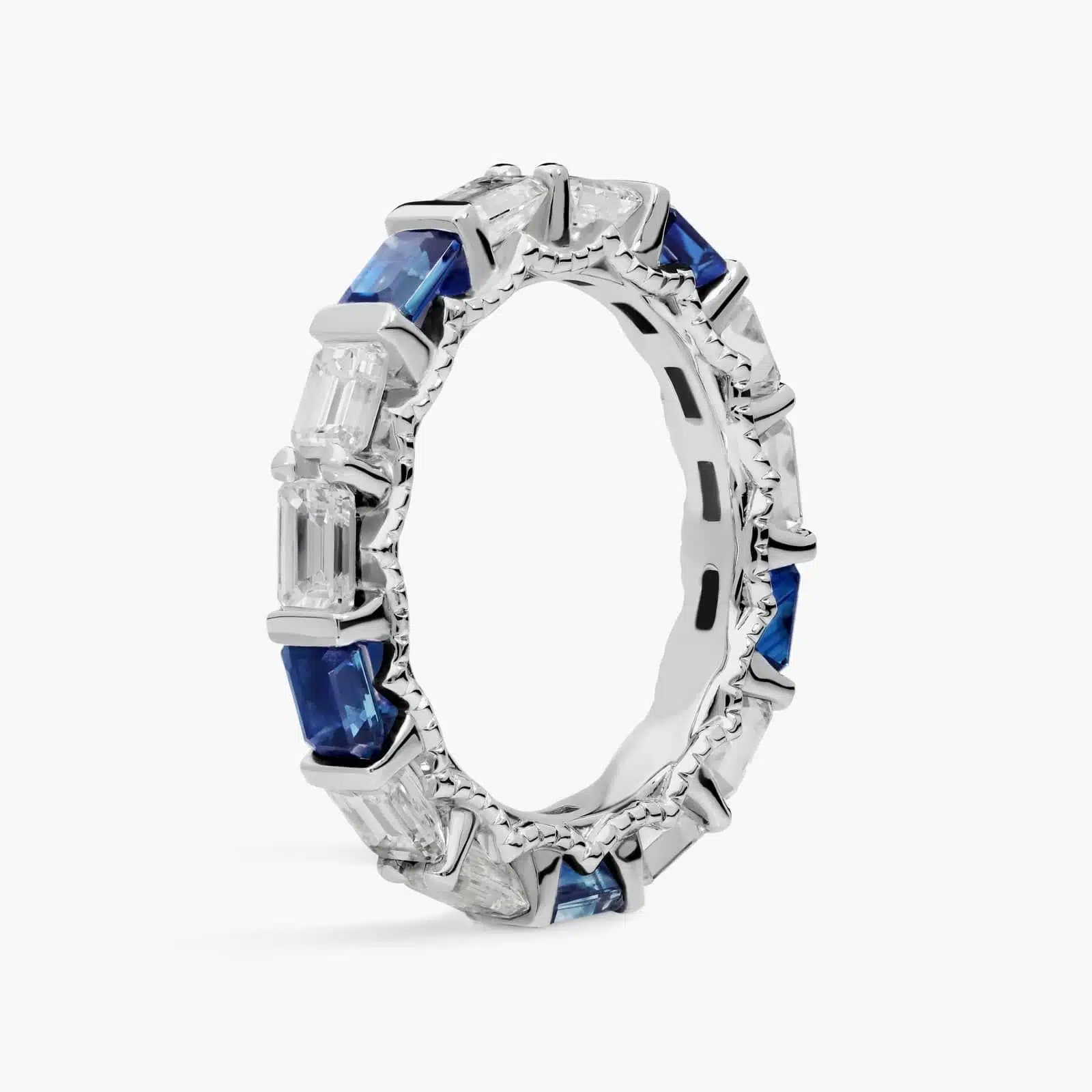 An Alternating East-West Emerald Cut Sapphire and Diamond Blue Wedding Rings For Women band (3.30mm) in 14K White Gold with over 2.5 CTW of stones.