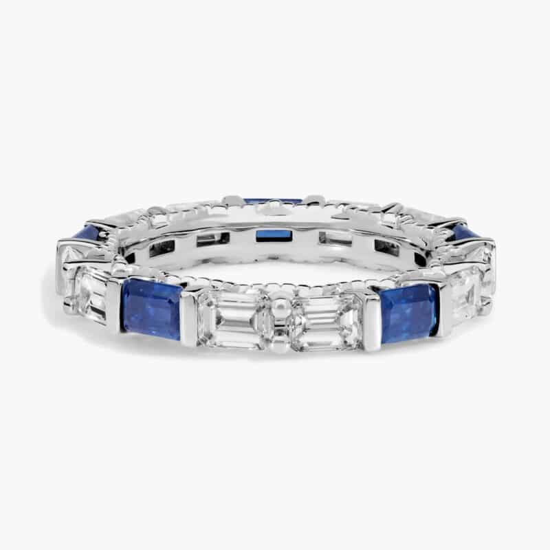 An Alternating East-West Emerald Cut Sapphire and Diamond Blue Wedding Rings For Women band (3.30mm) in 14K White Gold with over 2.5 CTW of stones.