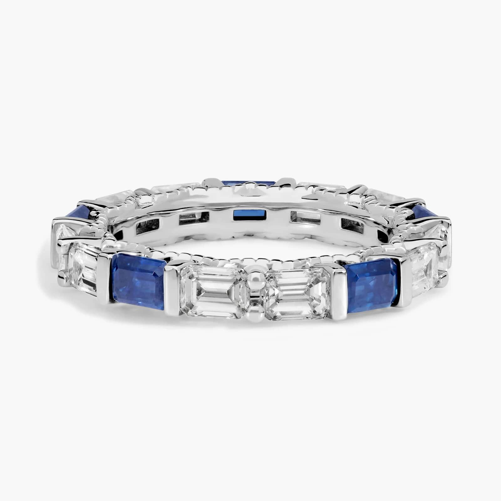 An Alternating East-West Emerald Cut Sapphire and Diamond Blue Wedding Rings For Women band (3.30mm) in 14K White Gold with over 2.5 CTW of stones.