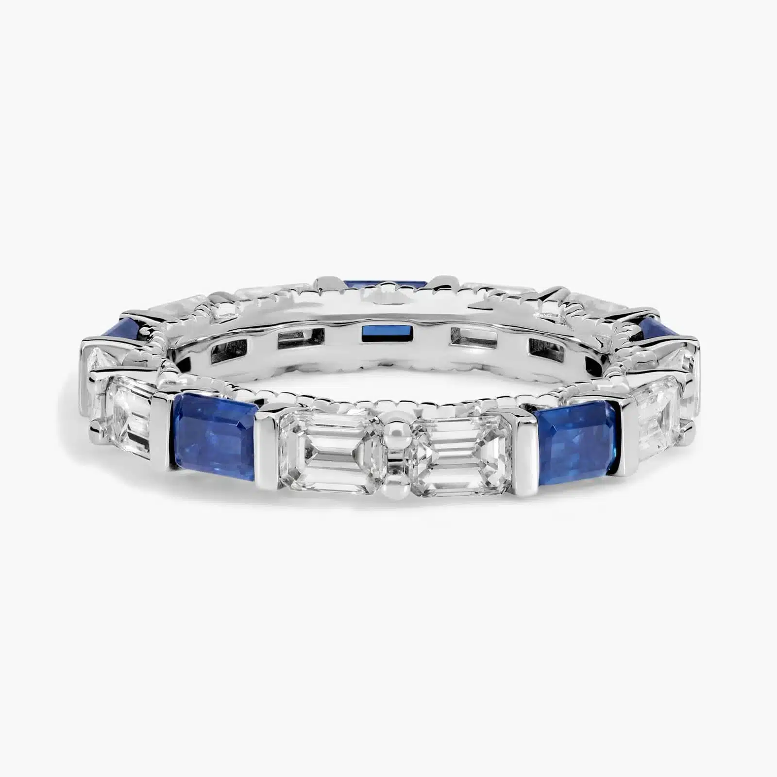 An Alternating East-West Emerald Cut Sapphire and Diamond Blue Wedding Rings For Women band (3.30mm) in 14K White Gold with over 2.5 CTW of stones.
