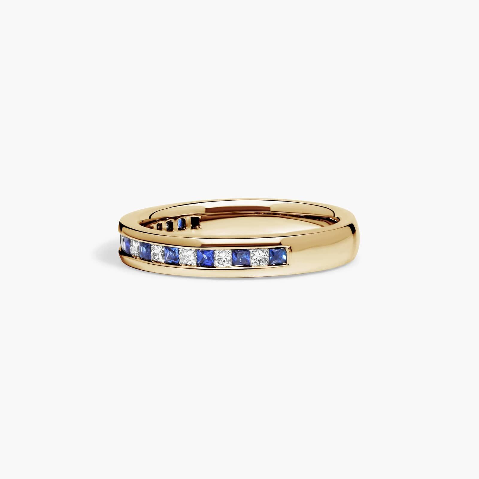 alternating-princess-cut-diamond-sapphire-yellow-gold-princess-cut-wedding-rings-18k 2 An 18K Yellow Gold Princess Cut Wedding Rings band (4.00 mm) featuring an alternating channel-set pattern of 0.5 CTW natural diamonds and blue sapphires.