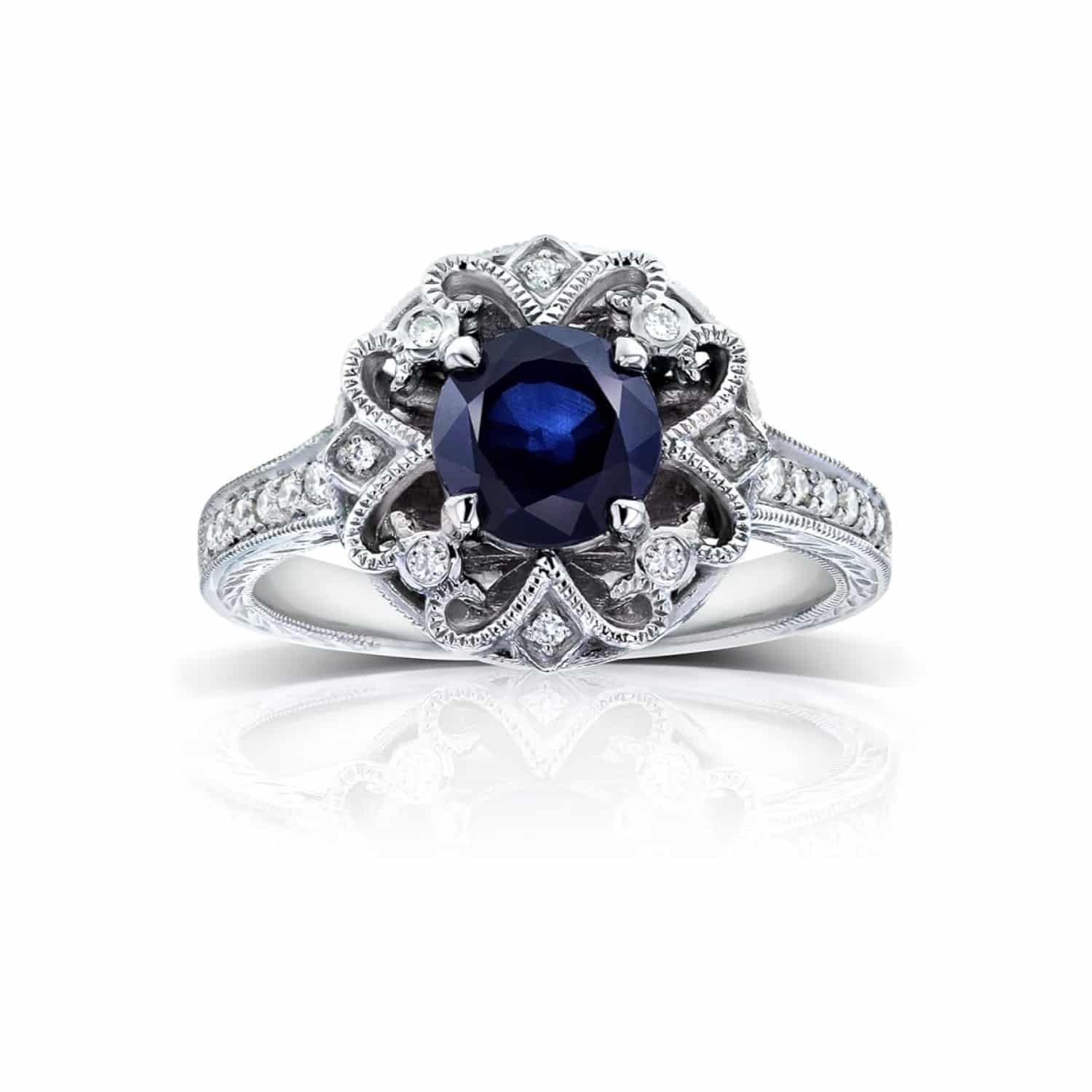 antique-floral-sapphire-diamond-vintage-art-deco-sapphire-rings-1-1-2ctw A 14K White Gold Antique Style Vintage Art Deco Sapphire Rings engagement ring featuring a 1.3 Carat Round Blue Sapphire center stone, a Floral Design, and a 1/5 CTW Pave set diamond halo.