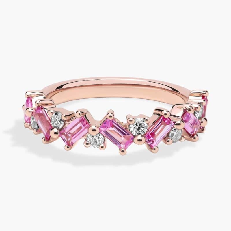 A 14K Rose Gold and Pink Sapphire Ring featuring 7 Baguette Pink Sapphires and 6 Round Diamonds (0.18 CTW) set in prongs, creating a romantic, emerald-style look on a 2.50 mm band.
