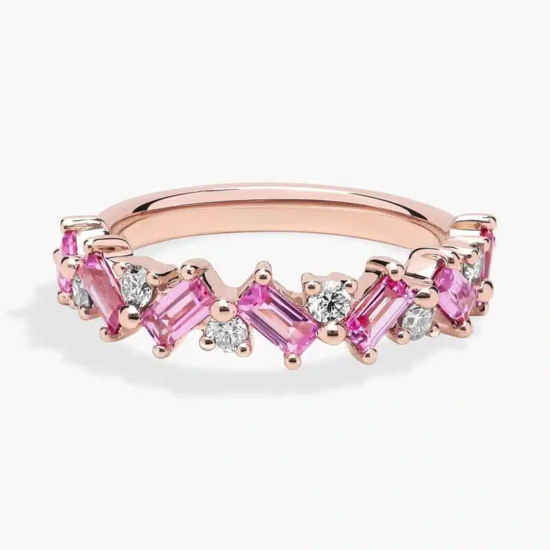 A 14K Rose Gold and Pink Sapphire Ring featuring 7 Baguette Pink Sapphires and 6 Round Diamonds (0.18 CTW) set in prongs, creating a romantic, emerald-style look on a 2.50 mm band.