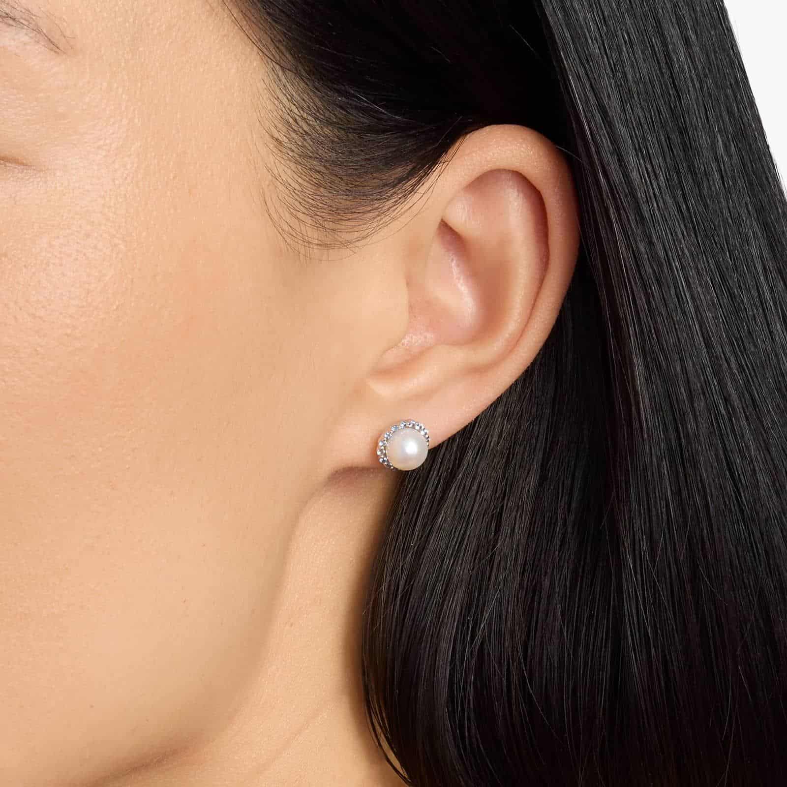 A pair of 14K White Gold Pearl and Sapphire Drop Earrings (Halo Stud style) featuring 7 mm Freshwater Cultured Pearls surrounded by a halo of 32 Round Blue Sapphires, secured with Push Backs.