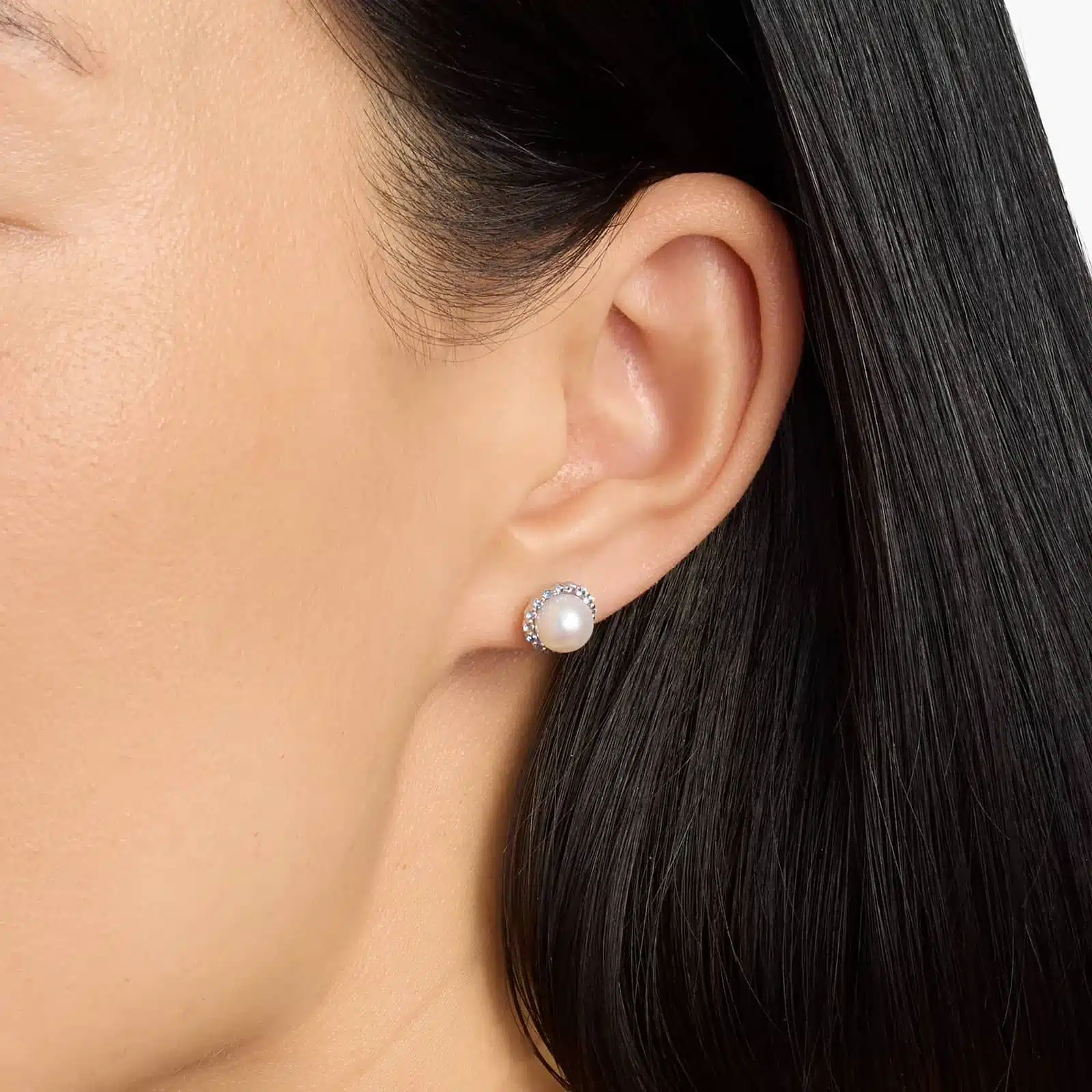 A pair of 14K White Gold Pearl and Sapphire Drop Earrings (Halo Stud style) featuring 7 mm Freshwater Cultured Pearls surrounded by a halo of 32 Round Blue Sapphires, secured with Push Backs.