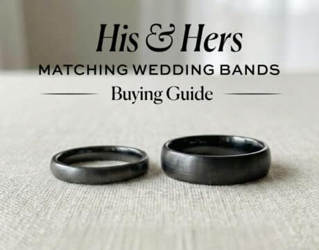 Black and gunmetal finish his and hers matching wedding bands (one narrow, one wide) on a beige linen surface, illustrating a guide to coordinating rings.