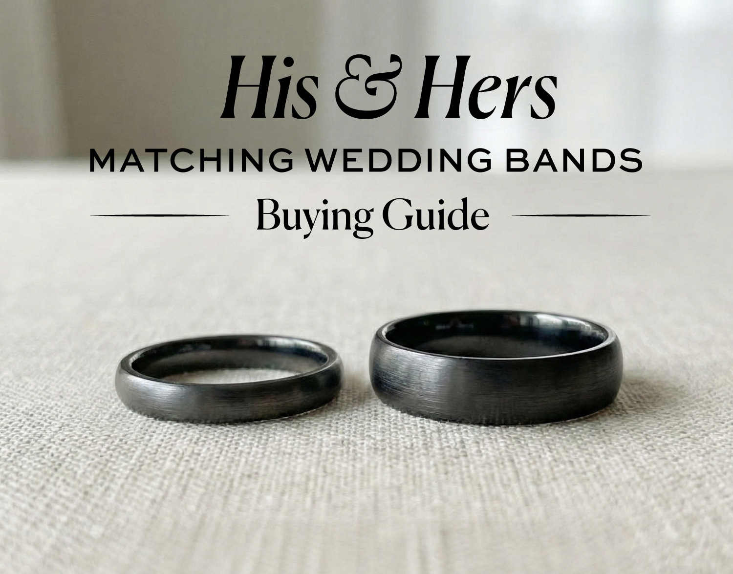 Black and gunmetal finish his and hers matching wedding bands (one narrow, one wide) on a beige linen surface, illustrating a guide to coordinating rings.