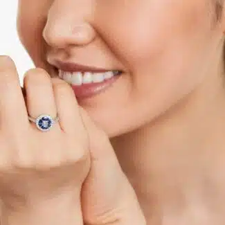 A 14K White Gold Princess Cut Diamond Ring with Sapphires, featuring four Marquise Blue Sapphires (0.62 CT min) set as flower petals, accented by a 0.18 CT Princess Cut Diamond and 0.28 CTW Round Diamonds.